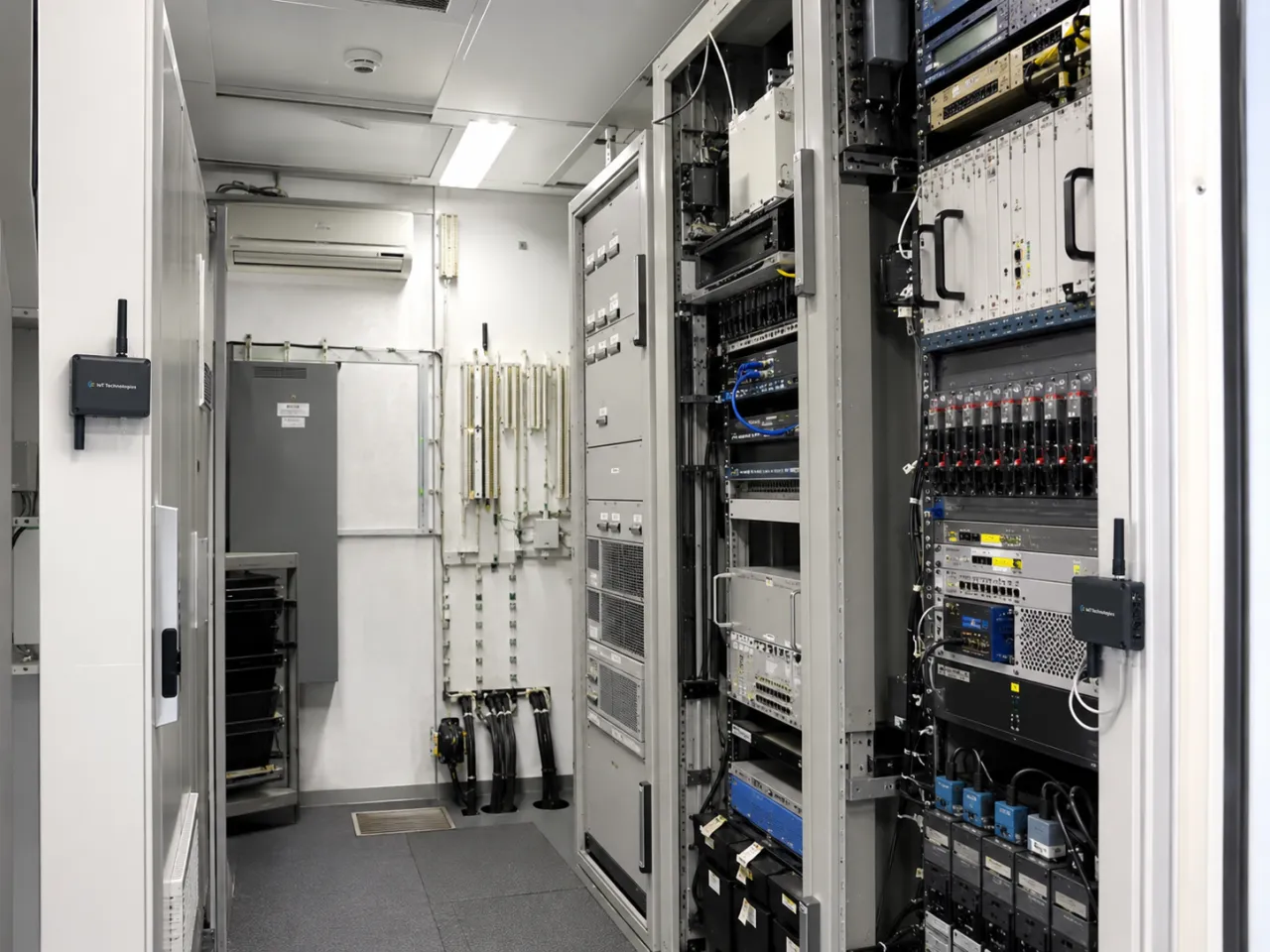 Illustrative unmanned telecoms equipment room with IoT Technologies monitoring tags fitted by the door and on the equipment rack.